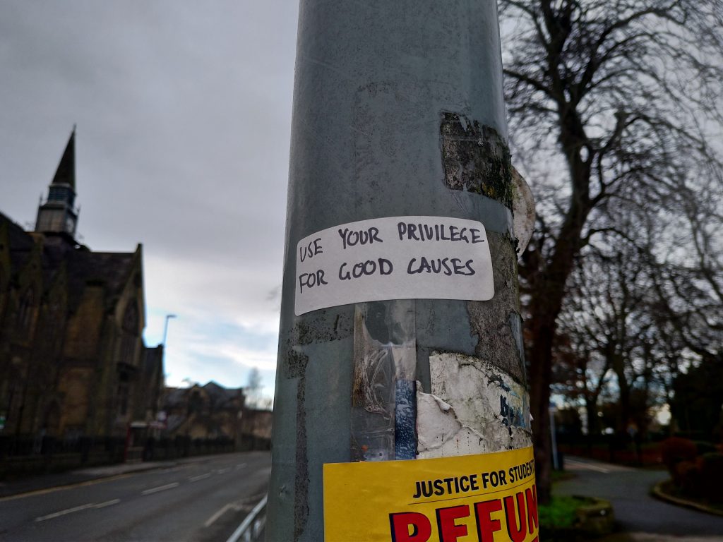 A pole with a sticker on saying "Use your privilege for good causes"