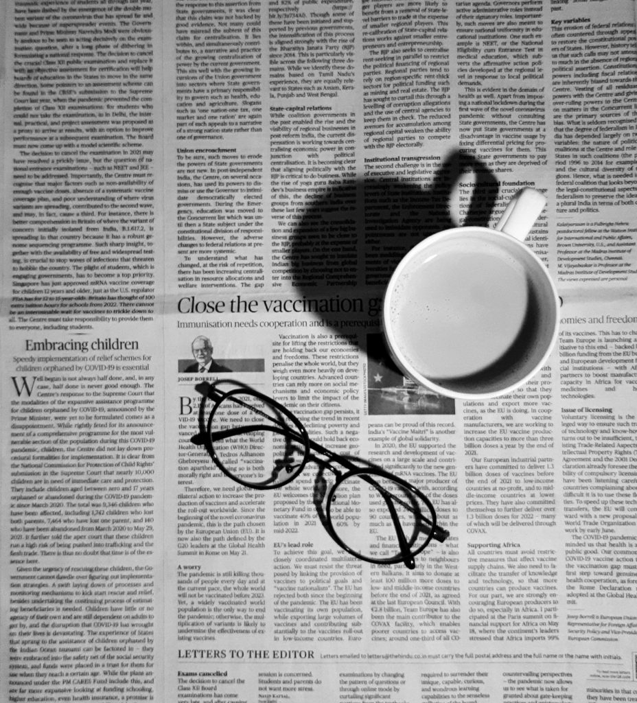 Glasses and a coffee mug placed on a newspaper, black and white
