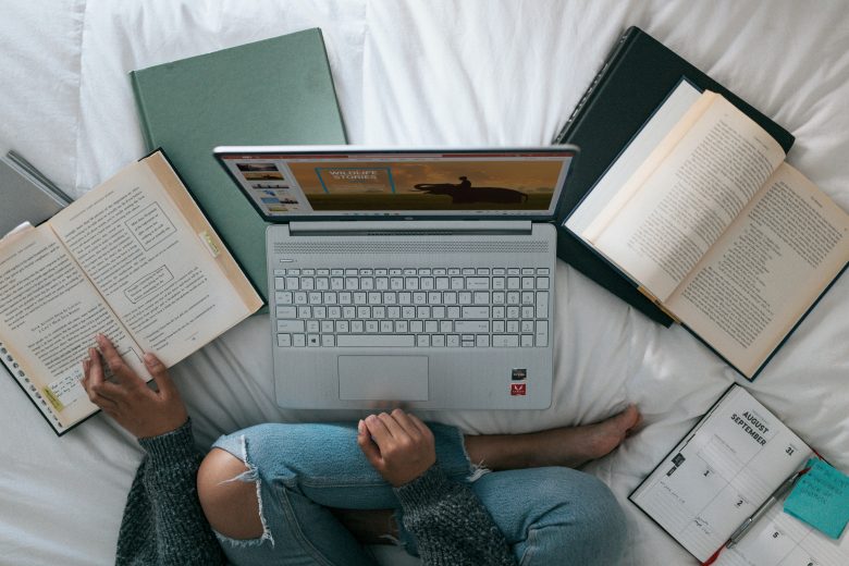 computer photographed from above amidst books and papers