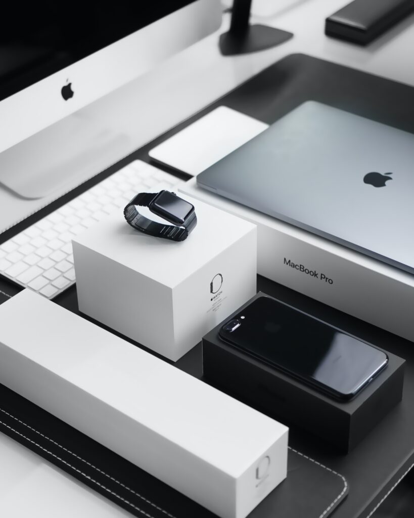 Multiple Apple Products on a table, an Apple Watch, an iPhone, a MacBook Pro