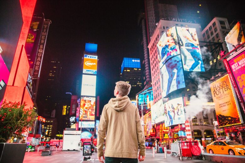 Person standing on time square looking at ads